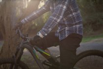 Середня частина людини з велосипедом, що стоїть на провулку — стокове фото