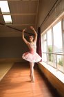Красива балерина практикує балетний танець в танцювальній студії — стокове фото