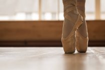 Baixa seção de bailarina dançando no chão de madeira no estúdio de dança — Fotografia de Stock