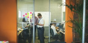 Gente de negocios discutiendo sobre tableta digital en la oficina - foto de stock