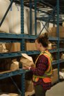 Female worker examining stock at warehouse — Stock Photo
