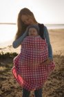 Primo piano della donna che porta il suo bambino sulla spiaggia — Foto stock