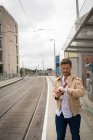 Чоловік перевіряє час на годиннику на платформі на залізничній станції — стокове фото