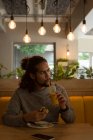 Молодой человек ест в кафе — стоковое фото