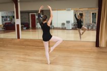 Ballerina dancing in front of mirror in dance studio — Stock Photo
