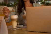 Seção média de mulher colocando pó de café na caneca de café no café — Fotografia de Stock