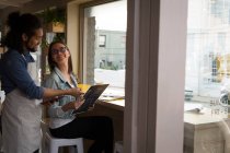 Mulher discutindo cartão de menu com garçom no café — Fotografia de Stock