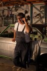 Mechaniker telefoniert in Garage mit Handy — Stockfoto