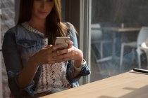 Женщина с помощью мобильного телефона в кафе — стоковое фото