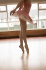 Bassa sezione di ballerina che balla sul pavimento in legno in studio di danza — Foto stock