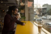 Молодий чоловік має каву в кафе — стокове фото