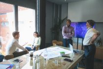 Geschäftsleute interagieren im Konferenzraum im Büro miteinander — Stockfoto