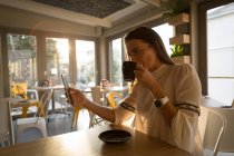 Женщина делает селфи во время кофе в кафе — стоковое фото