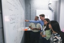 Geschäftsleute diskutieren über Whiteboard im Büro — Stockfoto