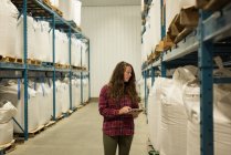 Женщина-работница с помощью цифрового планшета на складе — стоковое фото