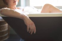 Donna che posa nella vasca da bagno in bagno — Foto stock