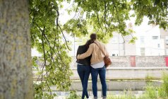 Rear view of couple standing near lakeside — Stock Photo