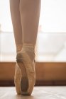 Low section of ballerina dancing on wooden floor in dance studio — Stock Photo