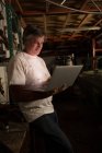 Чоловік-механік використовує ноутбук в гаражі — стокове фото