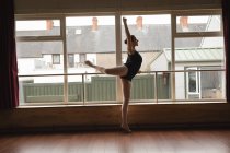 Ballerine pratique la position de ballet arabesque en studio de danse — Photo de stock