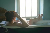 Visão traseira da mulher tomando banho na banheira no banheiro — Fotografia de Stock