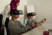Piloto do sexo feminino que dá formação sobre auscultadores de realidade virtual a estudantes do instituto de formação — Fotografia de Stock