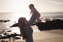 Mãe feliz brincando com bebê na praia — Fotografia de Stock