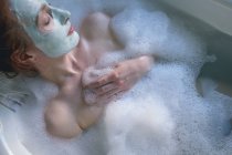 Woman relaxing in bathtub at bathroom — Stock Photo