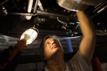 Чоловічий механізм вивчення автомобіля в гаражі — стокове фото