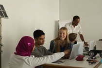 Estudiantes discutiendo sobre el ordenador portátil en el instituto de formación - foto de stock