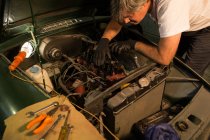 Meccanico maschio di manutenzione di un'auto in garage — Foto stock