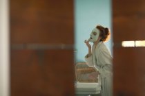 Woman applying facial mask at home — Stock Photo