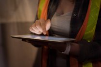 Mid section of female worker using digital tablet in warehouse — Stock Photo