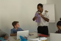 Молодой пилот обучает детей в учебном заведении — стоковое фото