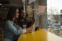 Jeune couple discutant carte de menu dans un café — Photo de stock