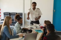 Pilot gibt Schülern im Ausbildungsinstitut Schulungen über Modellflugzeuge — Stockfoto
