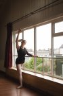 Bailarina practica ballet arabesco en estudio de danza - foto de stock