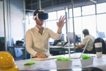 Male executive using virtual reality headset in office — Stock Photo