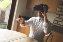 Человек с помощью гарнитуры виртуальной реальности дома — стоковое фото