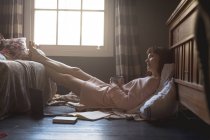 Жінка розслабляється з ногами вгору у вітальні вдома — стокове фото