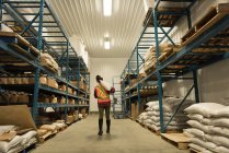 Rear view of female worker carrying bulk bag at warehouse — Stock Photo