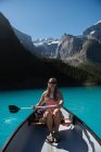 Bella donna in barca a cavallo nel fiume — Foto stock