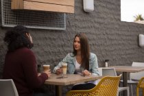 Молодая пара разговаривает друг с другом в кафе на открытом воздухе — стоковое фото