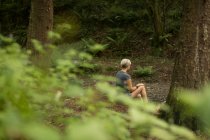 Задумчивая женщина отдыхает в лесу — стоковое фото