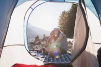 Casal relaxante perto da tenda em um dia ensolarado — Fotografia de Stock