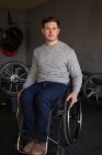 Junger behinderter Mann im Rollstuhl in Werkstatt — Stockfoto