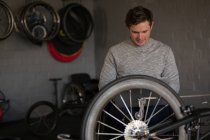Junger behinderter Mann repariert Rollstuhl in Werkstatt — Stockfoto