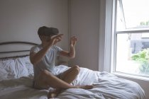 Человек использует гарнитуру виртуальной реальности в спальне дома — стоковое фото