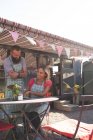 Couple travaillant près de camion de nourriture par une journée ensoleillée — Photo de stock