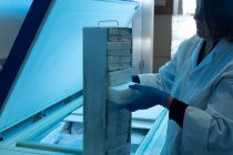 Female scientist removing ice cube in laboratory — Stock Photo